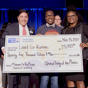 United Way president and CEO Pete Najera presents an oversized check to representatives of a winning nonprofit at the first ever Impact on the Plains event.