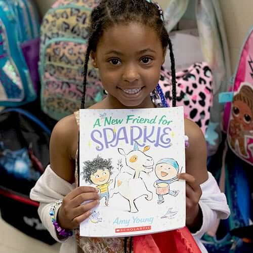 A third grade student shows off one of the books he received from United Way's Fight for Literacy campaign.