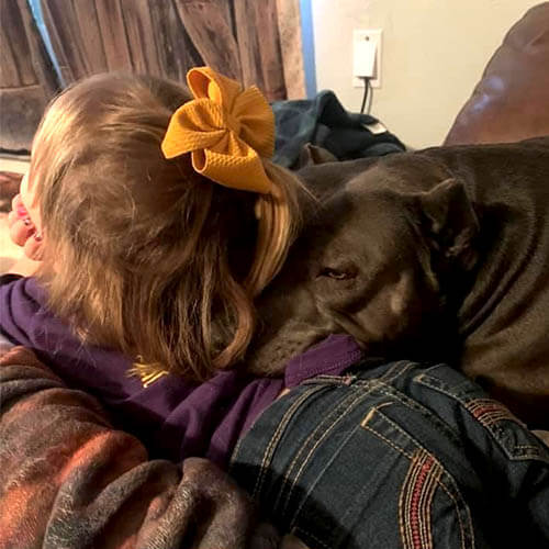 Brooklyn Hamilton's daughter relaxes with their family dog. 