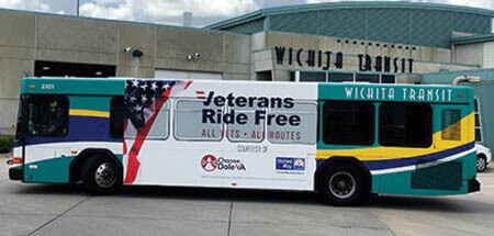 A side view of a Wichita City Transit bus that's wrapped in artwork advertising the Veterans Ride Free program.
