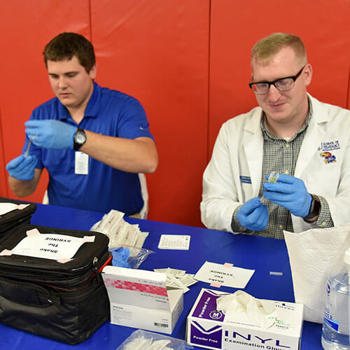 Students from KU School of Pharmacy organize supplies at the Operation Immunization free flu vaccine clinic.