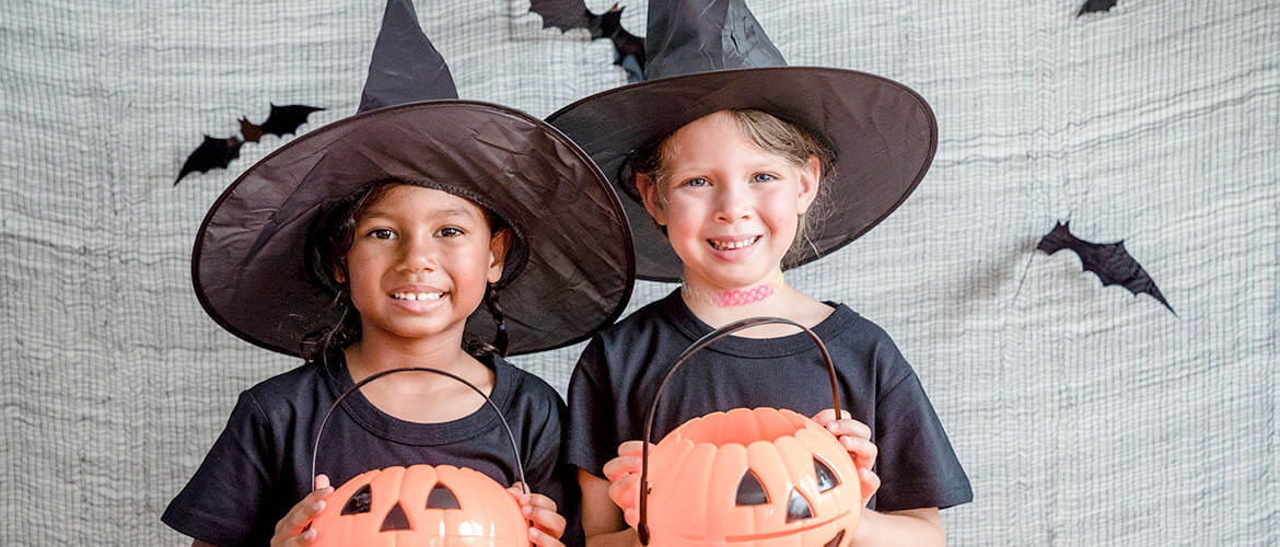 Two elementary age girls are dressed up as witches for Halloween.