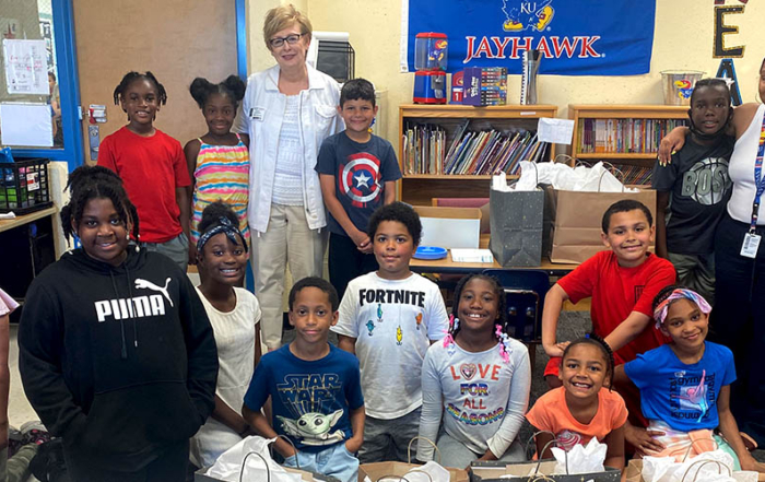 Cindy Grunewald, a volunteer reading coach with the United Way Read to Succeed program, poses with a class of third grade students.