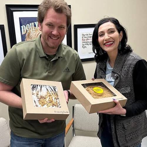 Bryan Ramsdale Anniversary Pie Day Bryan Ramsdale poses with Jessie Gorges-Sawhill. Both are holding pies in celebration of National Pie Day.