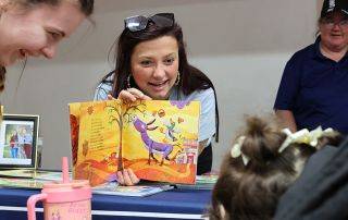 Brooklyn Black, United Way Associate Director of Philanthropy, reads a book to a child at a community outreach event.
