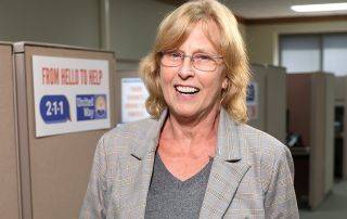 Cecilia Wood, United Way 211 Resource Navigator, poses in the call center.
