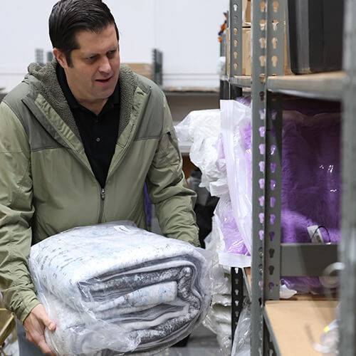A volunteer stocks new corporate donations at the United Way Give Items of Value Warehouse where nonprofits can shop for free.