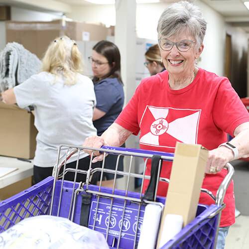 A volunteer stocks newly donated items at the Give Items of Value Warehouse for nonprofits to access at no charge.
