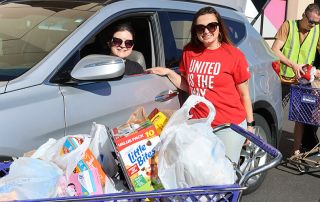 United Way of the Plains staff accept donations at a food drive.