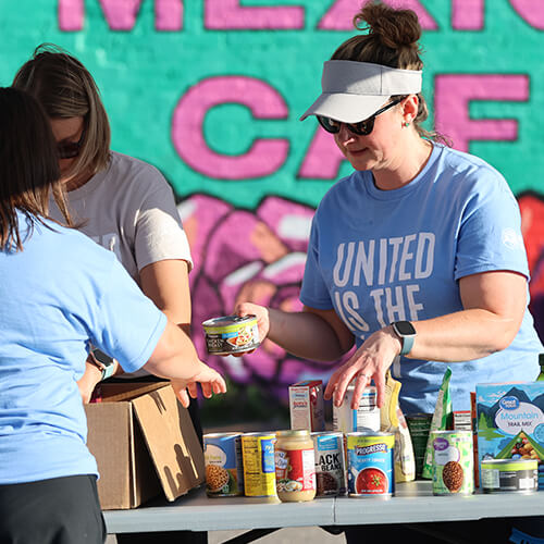United Way staff organize donations at a food drive.