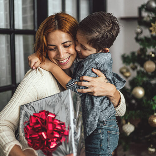 A mom and son enjoy Christmas morning thanks to the holiday resources they access through United Way of the Plains.