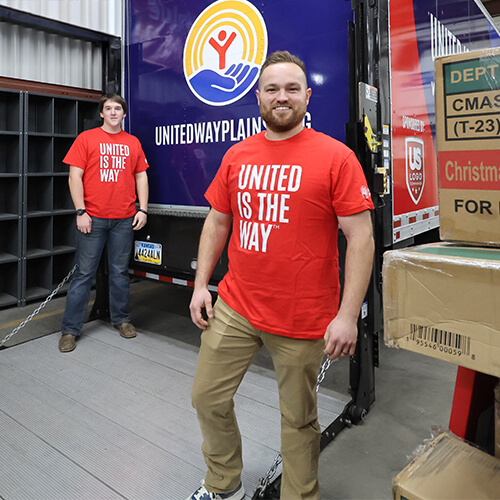 GIV Warehouse staff pose in front of the box truck used to pick up and deliver merchandise.