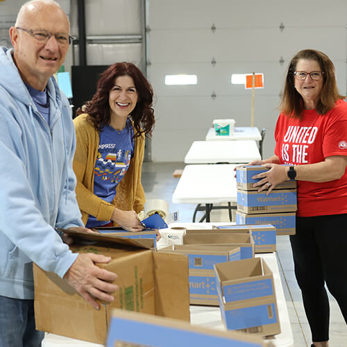 Serve United_500 x 500_V3 Members of Serve United volunteer together, helping to pack boxes of hygiene supplies for a local nonprofit.