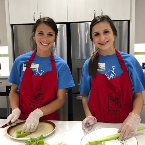 Two women volunteering to cook a meal at a nonprofit.