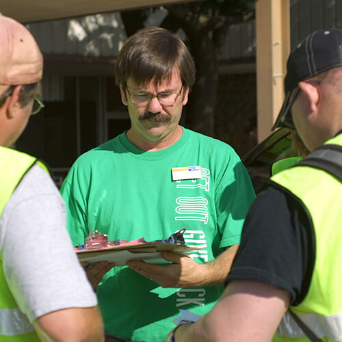 United Way disaster director working with volunteers at a tornado disaster site.